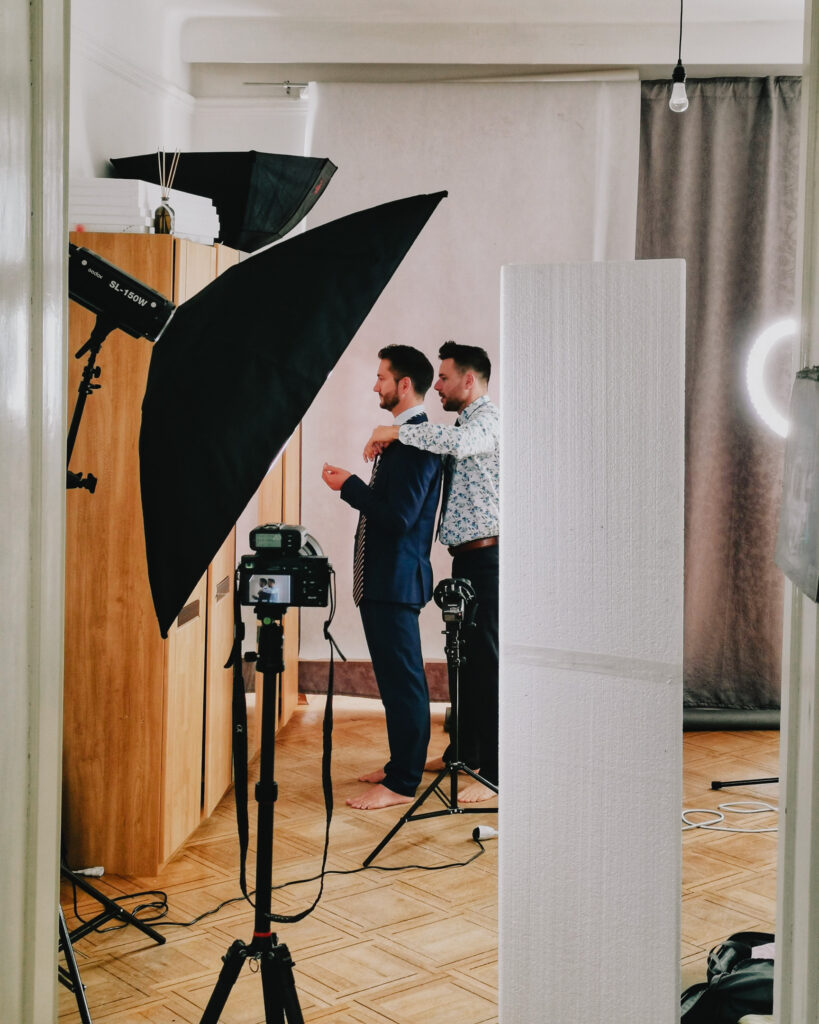 Behind the scenes Foto - 2 Männer bereiten sich auf Headshot Session vor und schauen in Spiegel